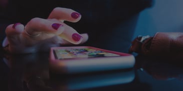 Woman looking at mobile apps on her phone - ACBM Solutions blog Building a Mobile App for Inventory Management Using Oracle Visual Builder Cloud Service