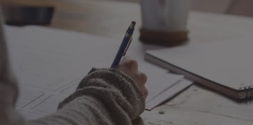 woman taking notes looking at files - ACBM blog - JDE Release 22 Makes Working with Attachments Easier