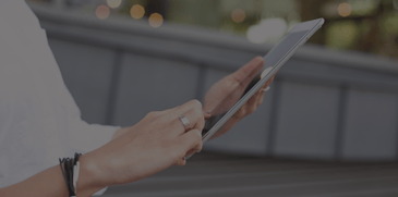 Woman looking at ACBM blog on tablet - blog header image - Creating a remittance email orchestration