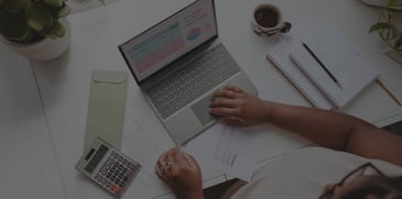 Woman using a laptop and calculator - ACBM blog - Why Is Fixing a COA So Difficult - and What Makes It Easier?