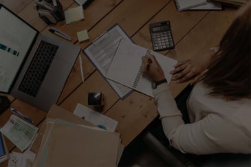 Woman working on financial report - Chart of Accounts with Cetova Reporting - ACBM Solutions blog header image